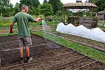 Biosphoto | 2575253 | Arche de la Nature gardener watering seedlings in the vegetable garden, Sarthe, France | &copy; Michel Gile / Biosphoto