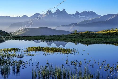 Biosphoto | 2610254 | Aurore sur le lac Guichard, au col de la Croix de Fer, en Maurienne, Savoie, Alpes, France. Des trèfles d'eau et des joncs colonisent ce lac peu profond situé à plus de 2000 mètres d'altitude en Savoie. A l'horizon, les 3 emblématiques Aiguilles d'Arves. | © Jean-Philippe Delobelle / Biosphoto