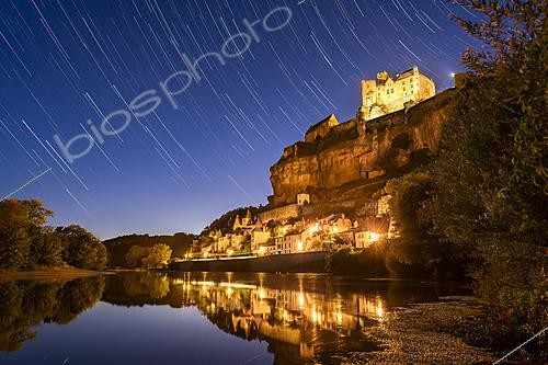 Biosphoto | 2624205 | Beynac Castle in Périgord. Nestled in a bend of the Dordogne River, the imposing medieval castle of Beynac-et-Cazenac overlooks the village nestled at the foot of its cliff. In the Middle Ages, the building was the seat of one of the four baronies of Périgord. During the hour-long pause, the stars trace their path across a clear sky, with the brightest ones on the left belonging to the constellation Leo. Within it, the orange hue of the planet Mars accompanies the star Regulus of Leo. Beynac-et-Cazenac, Dordogne, France. | &copy; Philippe Jacquot / Biosphoto