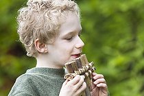 Biosphoto | 1254817 | Boy playing of a panpipe made of reed | &copy; Frédérique Bidault / Biosphoto