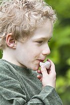 Biosphoto | 1254813 | Boy whistling with a snail shell | &copy; Frédérique Bidault / Biosphoto