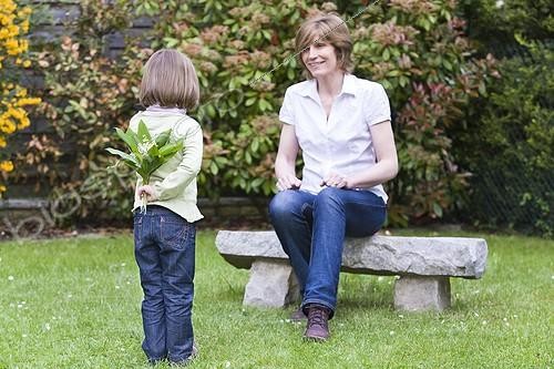 Biosphoto | 962025 | Child hiding a bouquet of lily of the valley for his mother | &copy; Frédérique Bidault / Biosphoto