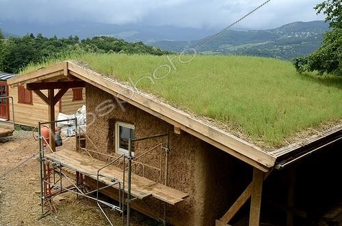 Biosphoto | 1363305 | Construction d'une maison en paille et toit végétalisé ; Pose de la première couche d'enduit d'argile et de paille. Orage dans la vallée de Munster | &copy; Denis Bringard / Biosphoto