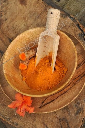 Biosphoto | 2517892 | Curcuma (Curcuma longa) épice en poudre et rhizome dans un bol en bois, fleur d'Azalée en décoration | &copy; Catherine Fruhinsholz / Biosphoto