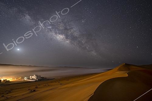 Biosphoto | 2624523 | Desert mist at the end of the night in the Omani desert of Wahiba Sands, the spring sky presents a rich galactic center filled with stars and gaseous nebulae. Above the camp, Venus shines brightly, dominating over Mars, while on the right side of the image, Alpha and Beta Centauri connect the Milky Way to the top of the dune, Wahiba Sands, Oman. | &copy; Philippe Jacquot / Biosphoto