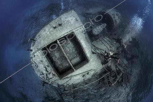 Biosphoto | 2615544 | El Condesito Wreck. It ran aground and sank in the early hours of September 27, 1973, after striking the rocks near Punta Rasca, in the south of Tenerife. Embedded in the basaltic cliffs, it rests at a maximum depth of about 18 meters. Of the bow, only the deck frames remain, along with a pile of wreckage: the boiler, cranes, metal plates, etc., and some hardened cement sacks that made up its main cargo. The stern, the best-preserved section, extends seaward. Its hold, wide and safe, is easy to access. The twisted propeller provides shelter for numerous fish. Canary Islands. | &copy; Sergio Hanquet / Biosphoto