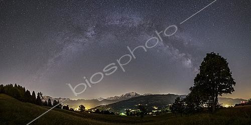 Biosphoto | 2624359 | Galactic arch, the Milky Way stretches above Mont Blanc from the heights of Megève. The Haute-Savoie resort illuminates the mountain behind the large tree. Lower in the valley, the lights of Saint-Gervais do not obscure the view of another galaxy, that of Andromeda, which appears quite small compared to ours. Located over 2 million light-years away, it will eventually merge with the Milky Way in more than 2 billion years. Megève, Haute-Savoie, France. | &copy; Philippe Jacquot / Biosphoto