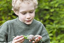 Biosphoto | 1254897 | Garçon observant un escargot sur une feuille | &copy; Frédérique Bidault / Biosphoto