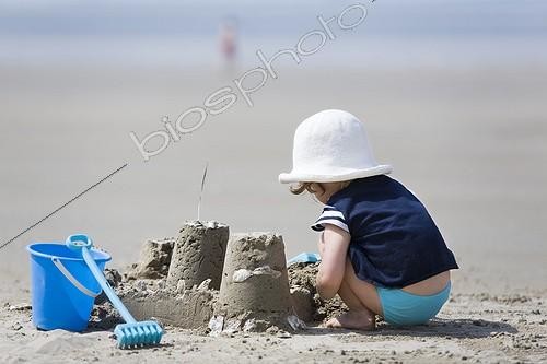 Biosphoto | 541292 | Girl and sandcastle on the beach Charentes France  ; Age : 2 years <br>Location: Saint Georges de Didonne | &copy; Frédérique Bidault / Biosphoto