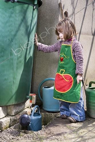 Biosphoto | 898934 | Girl filling his watering can with water from rain France ; Age: 4 years  | &copy; Frédérique Bidault / Biosphoto