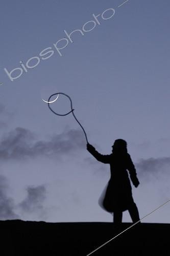 Biosphoto | 1255220 | Girl giving the impression of getting to lasso the moon  | &copy; Laurent Laveder / Biosphoto