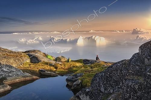 Biosphoto | 2614959 | Large glaciers in the bay by the rocky shore in the light of the setting sun with fog over the water, woman in a red cap | &copy; Jaroslav Sugarek / imageBROKER / Biosphoto