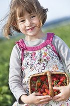 Biosphoto | 1252393 | Little girl carrying a basket of strawberries | &copy; Frédérique Bidault / Biosphoto