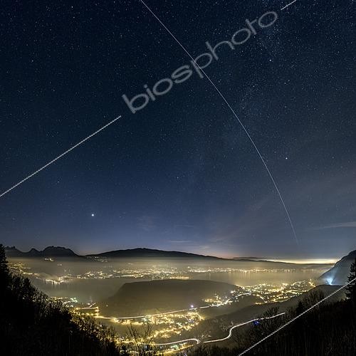 Biosphoto | 2624566 | Passage of the ISS over Lake Annecy and the bright star Vega on the left, while the planet Venus shines brilliantly in the twilight. The Duingt peninsula is visible on the left side of the image, and the powerful floodlights of the Château de Menthon St Bernard illuminate the sky on the right. The mass of the Roc de Chère nature reserve divides the lake in two. Talloires, Lake Annecy, Haute-Savoie, France. | &copy; Philippe Jacquot / Biosphoto