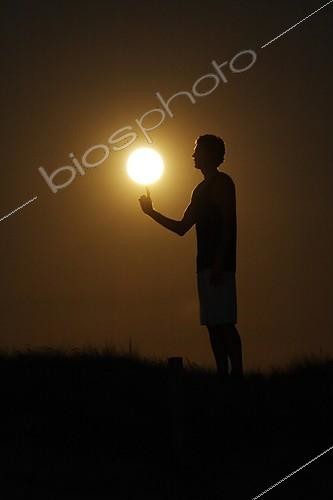 Biosphoto | 1159859 | Personne donnant l'impression de jouer au basket avec Lune ; Un basketteur fait tournoyer la Pleine Lune au bout de son doigt | &copy; Laurent Laveder / Biosphoto