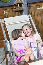 Biosphoto | 1252398 | Petites filles jouant avec un arrosoir sur une chaise longue | &copy; Frédérique Bidault / Biosphoto