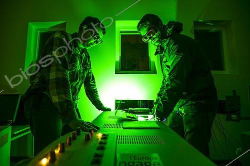 Biosphoto | 2072287 | Preparation of a Lidar laser at Maïdo,Observatoire de Physique de l'Atmosphère de la Réunion (OPAR). Reunion Island. Guillaume Payen, OPAR's technical manager, and Nicolas Marquestaut, research engineer, prepare the lasers for the night's shooting. These lidar lasers are designed to analyze certain components of the atmosphere. The Maïdo atmospheric observatory on La Réunion (one of the 3 measurement sites of the OPAR (Observatoire de Physique de l'Atmosphère de La Réunion), has been installed since October 2012 on the Piton Maïdo at an altitude of 2,200 meters. The laboratory is equipped with active and passive remote sensing instrumentation, enabling long-term, high-quality measurements of the vertical profiles of numerous climatic variables. It enables us to monitor atmospheric and climatic parameters in a context of accelerating climate change, and benefits from a unique situation in the tropical southern hemisphere, where observations are extremely rare. The observatory has 4 laser lidars, 2 of which are visible (green), and 2 invisible to the human eye. Three of the lidars are fired vertically, and one at 45 degrees, to measure wind. (i) One lidar is dedicated to measuring water vapour, with a large 1.20 m diameter telescope and two paired lasers. (ii) Three other LIDARS are designed to measure vertical profiles of atmospheric parameters (including one fired at 45 degrees, for wind measurements). The Maido observatory benefits from several major advantages. (1) Its latitudinal position for studying stratospheric transport processes. (2) Its altitude, free from pollution, humidity and light, considerably improves the quality of remote sensing measurements for studying the chemical composition of the atmosphere. OPAR's observations are part of several international observation networks, including NDACC (Network for the Detection of Atmospheric Composition Changes) and GAW (Global Atmospheric Watching). | &copy; Thibaut Vergoz / Biosphoto