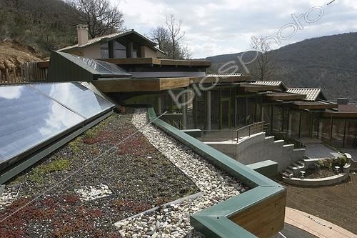 Biosphoto | 594016 | Solar panels and vegetalized roof of an individual France ; Location: Fondamente.<br>Plant species used: white Stonecrops (Sedum album), Stonecrops (Sedum sediforme), Fuldagluts (Sedum spurium 'Fuldaglut'), Armenia Stonecrops (Sedum spurium 'Tricolor') and Sempervivum (Sempervivum sp). | &copy; Nathalie Vanherle / Biosphoto