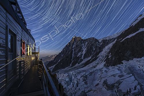 Biosphoto | 2624321 | Star trails above the Grands Mulets Refuge overlooking the crevassed Bossons Glacier descending from the cursed valley. Opposite, the summit of the Aiguille du Midi is illuminated by the full moon, while the International Space Station passes by before disappearing behind the Cosmiques Refuge. Chamonix-Mont-Blanc, Haute-Savoie, France. | &copy; Philippe Jacquot / Biosphoto