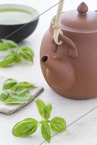 Biosphoto | 1164884 | Tisane de feuilles de Basilic dans une tasse ; Une tisanière en terre et des feuilles de basilic sur un plan de travail en pierre | &copy; Frédérique Bidault / Biosphoto