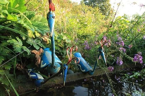 Biosphoto | 754174 | Watering place and metal birds Garden of Marie-Ange France ; Down of the garden, the meadow full of flowers leads these metal figurines to the orchard with at the entrance | &copy; Hervé Lenain / Biosphoto